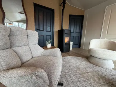 a living room with a chair and a fireplace at Beautiful house on an island near Amsterdam in Oude Meer