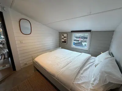 a small bedroom with a white bed in it at Beautiful house on an island near Amsterdam in Oude Meer