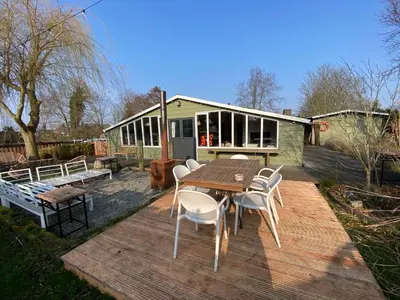 a patio with a table and chairs and a house at Beautiful house on an island near Amsterdam in Oude Meer