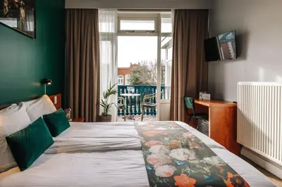 a hotel room with a bed and a window at Hotel Keur in Zandvoort