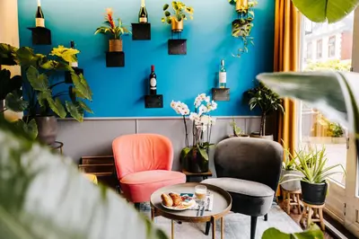a room with two chairs and a table and a blue wall at Hotel Keur in Zandvoort