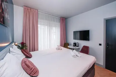 a hotel room with a large white bed with pillows at Hotel Keur in Zandvoort