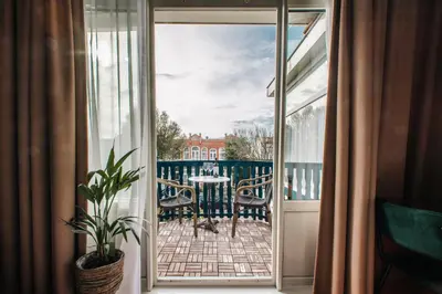 an open door to a balcony with a table and chairs at Hotel Keur in Zandvoort