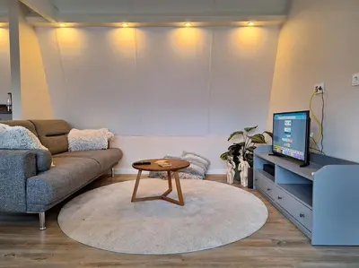 a living room with a couch and a table at Have a nice stay! - De Pottenbakkerij in Noordwijk