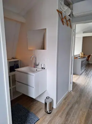 a white bathroom with a sink in a room at Have a nice stay! - De Pottenbakkerij in Noordwijk
