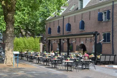 a group of tables and chairs in front of a building at Van Rossum Stadshotel Woerden in Woerden