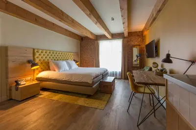 a bedroom with a bed and a desk and a window at Van Rossum Stadshotel Woerden in Woerden