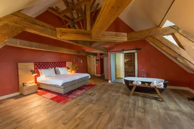 a bedroom with a bed and a tub in it at Van Rossum Stadshotel Woerden in Woerden