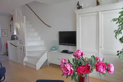 a living room with a vase of pink flowers at Seapearl in Zandvoort