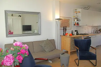 a living room with a couch and a kitchen at Seapearl in Zandvoort