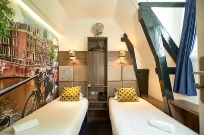 two beds in a room with a mural on the wall at The Townhouse Hotel in Amsterdam