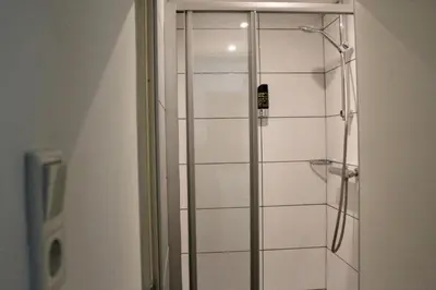 a shower with a glass door in a bathroom at The Townhouse Hotel in Amsterdam
