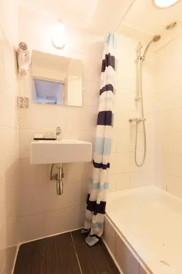 a bathroom with a sink and a tub and a shower at The Townhouse Hotel in Amsterdam