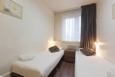 two beds in a room with a window at The Townhouse Hotel in Amsterdam