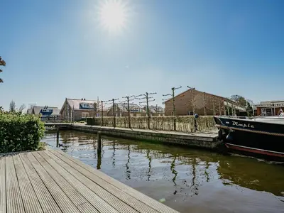 a boat is docked at a dock on a river at Westergeest in Uitgeest