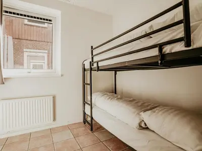 a bedroom with a bunk bed and a window at Westergeest in Uitgeest