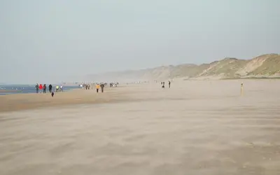 a group of people walking on the beach at Zomerhuisje Wijk aan Zee in Wijk aan Zee