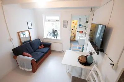 a living room with a blue couch and a table at Zomerhuisje Wijk aan Zee in Wijk aan Zee