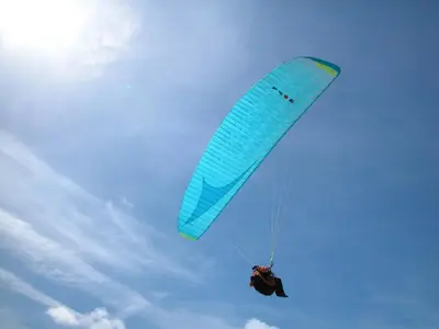 a person riding a blue parachute in the sky at Zomerhuisje Wijk aan Zee in Wijk aan Zee