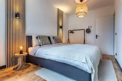 a bedroom with a large bed and a table at CanalView Luxury Apartment in Amsterdam