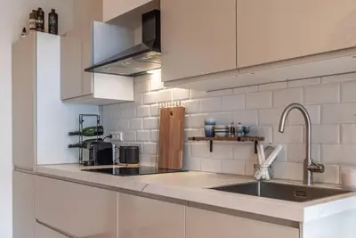 a kitchen with white cabinets and a sink at CanalView Luxury Apartment in Amsterdam