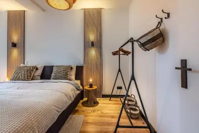 a bedroom with a bed and a cross on the wall at CanalView Luxury Apartment in Amsterdam