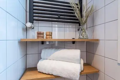 a shelf in a bathroom with towels on it at CanalView Luxury Apartment in Amsterdam