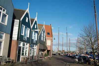 a row of houses on a street with parked cars at Apartments Waterland in Monnickendam