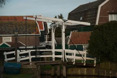 a white bridge over a river with houses at Apartments Waterland in Monnickendam