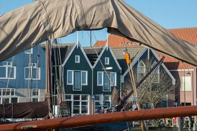 a view of a boat with houses in the background at Apartments Waterland in Monnickendam