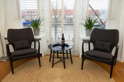 two chairs and a table in a room with a window at Apartments Waterland in Monnickendam