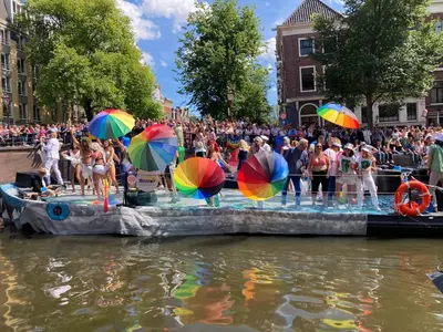a group of people with umbrellas in the water at Charming Rooms with free parking in Amsterdam