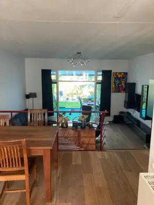 a living room with a table and a dining room at Charming Rooms with free parking in Amsterdam