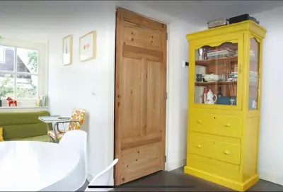 a yellow cabinet next to a door in a room at Tiny house Watergang in Watergang