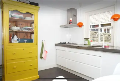 a kitchen with a yellow cabinet in a kitchen at Tiny house Watergang in Watergang