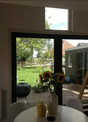a vase of sunflowers sitting on a table in front of a window at Tiny house Watergang in Watergang