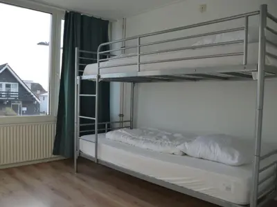 two bunk beds in a room with a window at Holiday apartment Seapaerdje in Bergen aan Zee