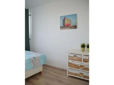 a bedroom with a bed and a dresser with a picture at Holiday apartment Seapaerdje in Bergen aan Zee