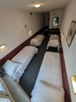 a room with four beds in the corner of a room at Budget Hotel Ben in Amsterdam