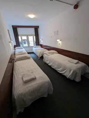 a room with four beds lined up in a row at Budget Hotel Ben in Amsterdam