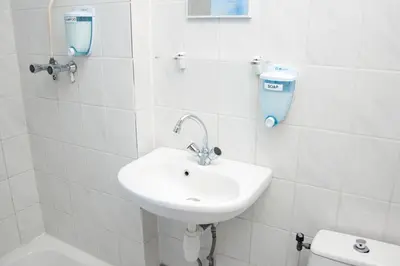 a white bathroom with a sink and a toilet at Budget Hotel Ben in Amsterdam