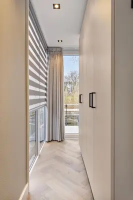 a hallway with white walls and a large window at Luxurious waterloft near beach and centre by Weltevreden Experience in Zeewolde