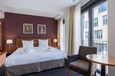 a hotel room with a bed and a table at Amrâth Grand Hotel Frans Hals in Haarlem