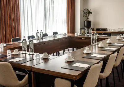a meeting room with a long table and chairs at Amrâth Grand Hotel Frans Hals in Haarlem