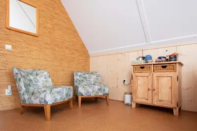 a room with two chairs and a wooden cabinet at Vegan B&B De Groene Mus in Wervershoof