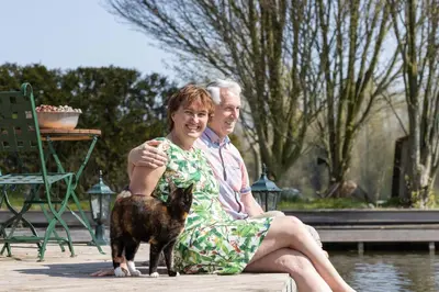 a man and a woman sitting next to a dog at Vegan B&B De Groene Mus in Wervershoof
