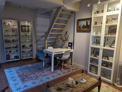 a room with a table and a spiral staircase at Het Pakhuis Haarlem in Haarlem