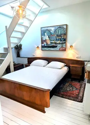 a bed in a room with a painting on the wall at Het Pakhuis Haarlem in Haarlem