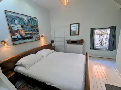 a bedroom with a bed and a painting on the wall at Het Pakhuis Haarlem in Haarlem