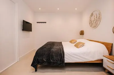 a bedroom with a bed and a tv on the wall at Simply studio's in Zandvoort